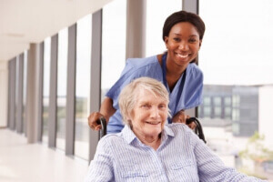 elderly woman in wheelchair with her caregiver